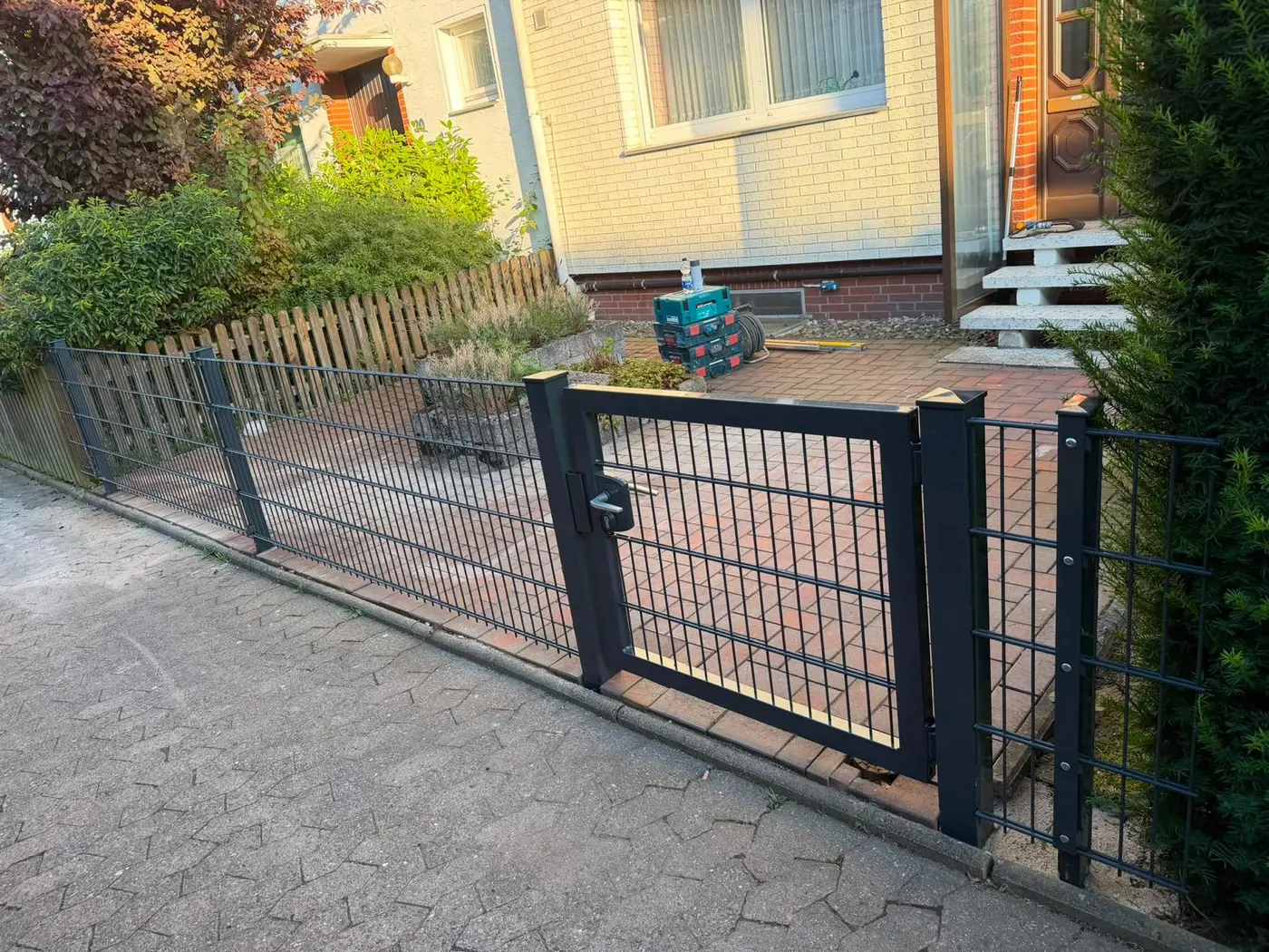 Nachher: neue schwarze Doppelstabmatten-Zaunanlage mit Tor