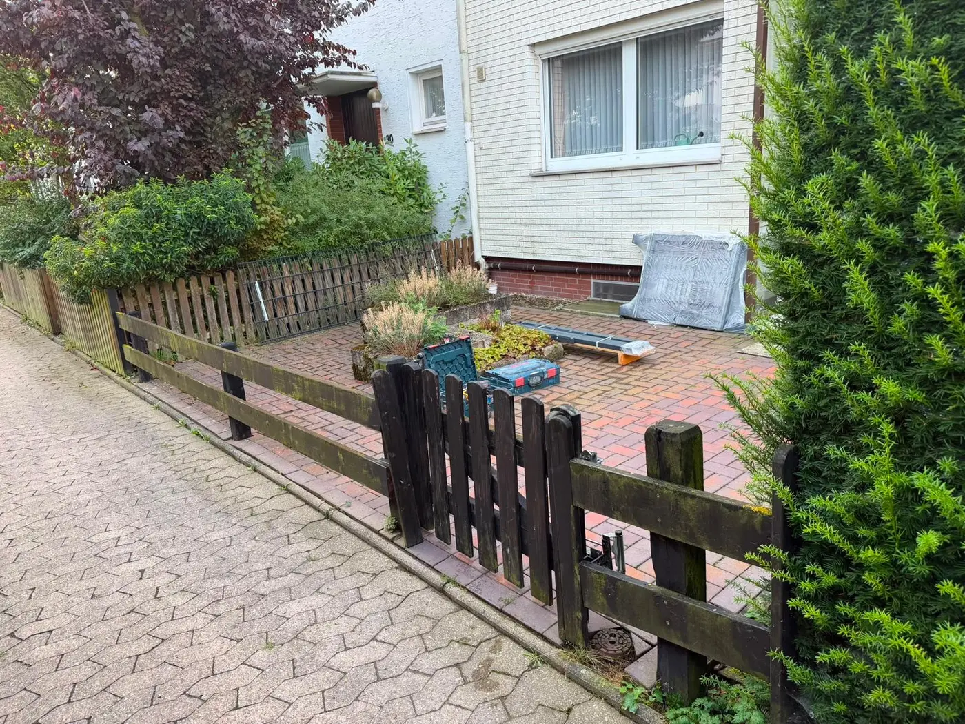 Vorher: alter Holzzaun vor einem Wohnhaus